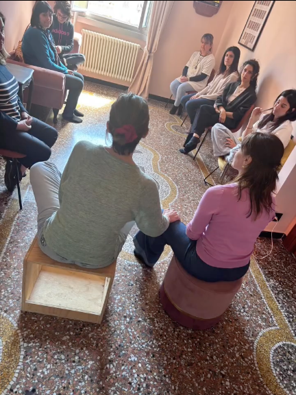 Un gruppo seduto in cerchio durante una sessione di Costellazioni Familiari nello studio di Valeria a Genova